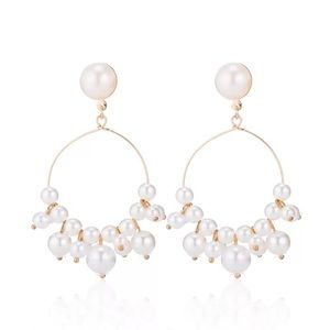 Gold and pearl dangle hoop earrings.